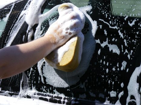 Photo of a person cleaning a car window