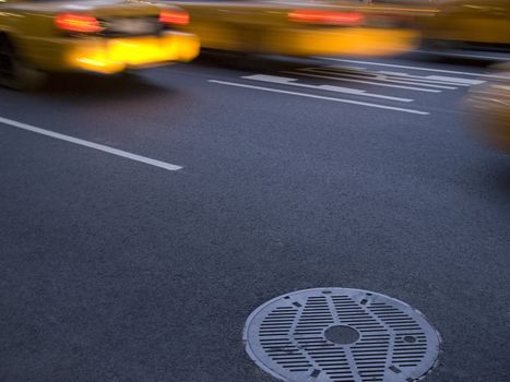 Several New York yellow cab running beside a culvert.