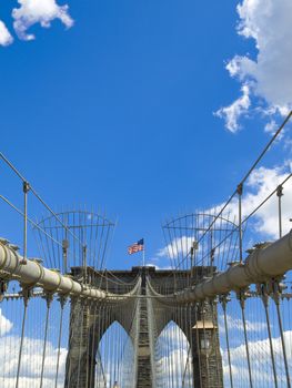 A view of the Brooklyn bridge with a blue sky on the background.