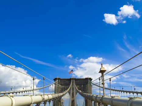 A view of the Brooklyn bridge with a blue sky on the background.