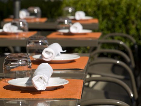 Restaurant set up tables on a sunny terrace.