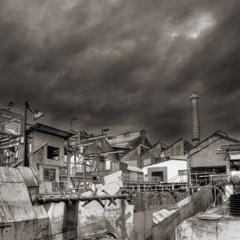 Industrial ruin of factory with dramatic clouds in sky.