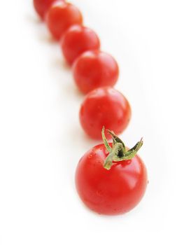 red cherry tomatoes in line isolated on white
