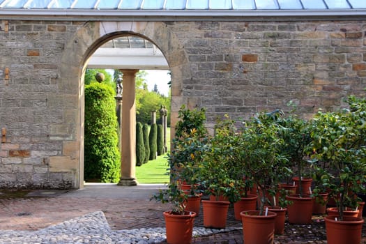 Arch in the brick wall, opens a view on the garden