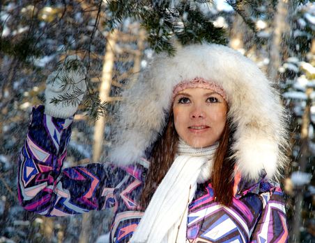 Young woman takes snow shower in the forest