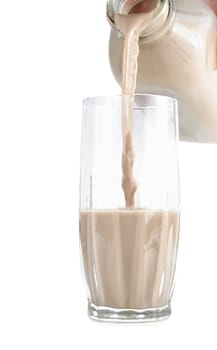 pouring chocolate milk on a glass