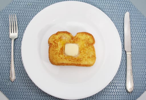 french toast with piece of butter on a white plate