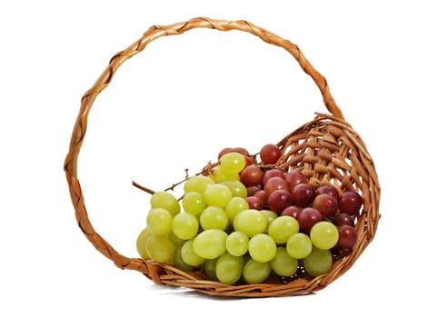 green and red grape in wicker basket, white background