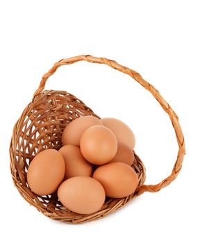 brown eggs in wicker basket, white background