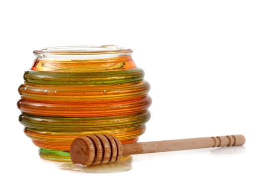 jar of fresh honey with wood stick, white background