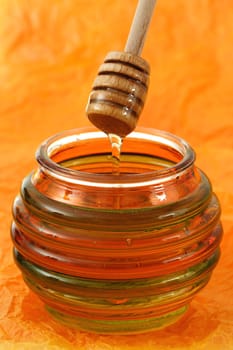 jar of fresh honey with wood stick