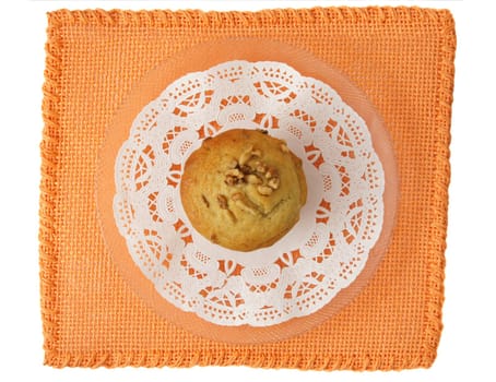muffin with nut on white decorative paper over an orange tablecloth
