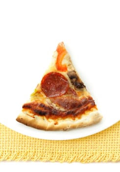 slice of all dressed pizza in white plate, yellow tablecloth