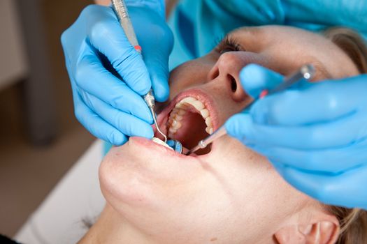 Dentist checking the mouth of her patient for cavities