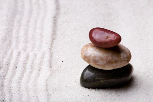 A stack of rocks in a zen rock garden with sand