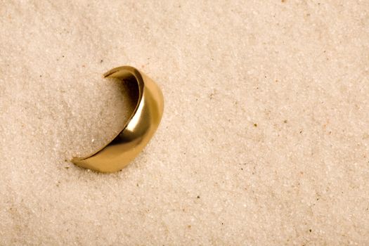 A wedding ring buried in the sand - lost