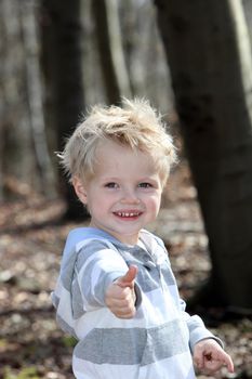 Small, blond boy shows the "thumbs up"