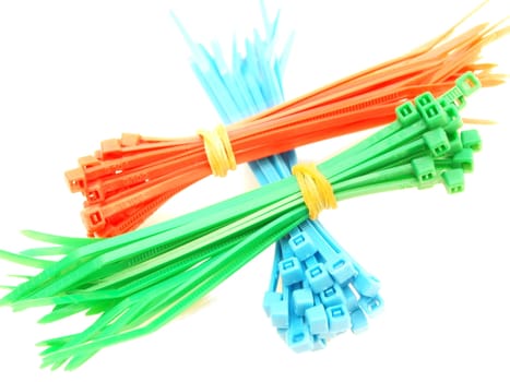 Blue, red, and green plastic wire ties in bundles on white background