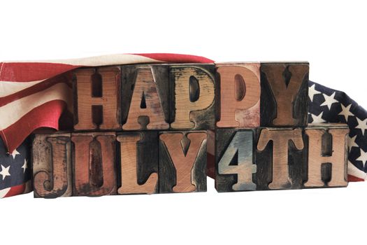 the phrase 'happy July 4th' in ink-stained letterpress type with flags draped behind
