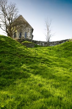 A stone church on a green meadow