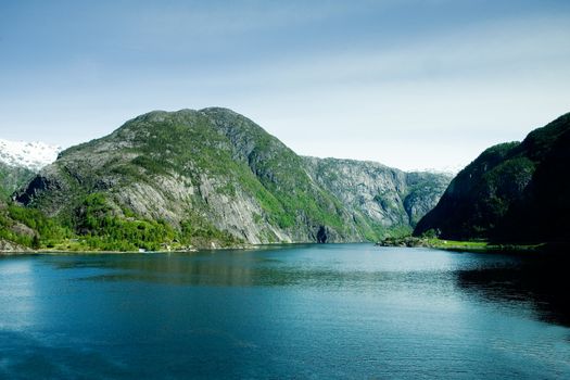 A fjord and rural norway with a blue sky