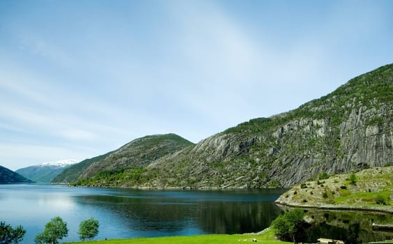 A fjord and rural norway with a blue sky