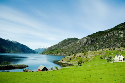 A fjord and rural norway with a blue sky