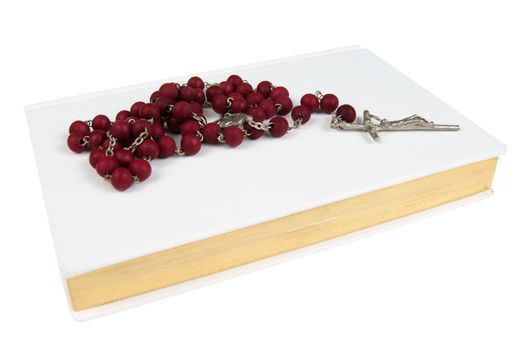 White prayer book with red rosary isolated on white background