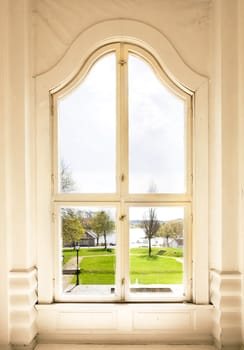 An old arched window view out to a garden