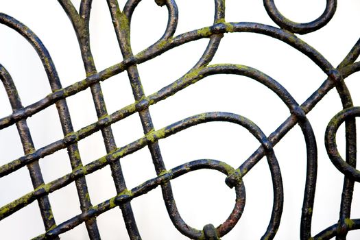 A wrought iron fence detail with slight moss covering