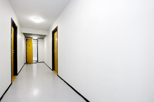 A sterile empty hallway with a single door open