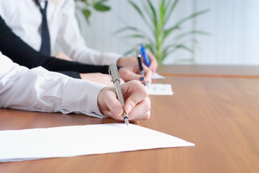 person's hand signing an important document