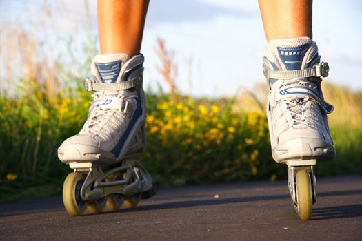 Rollerblades in action closeup on a sunny summer evening.