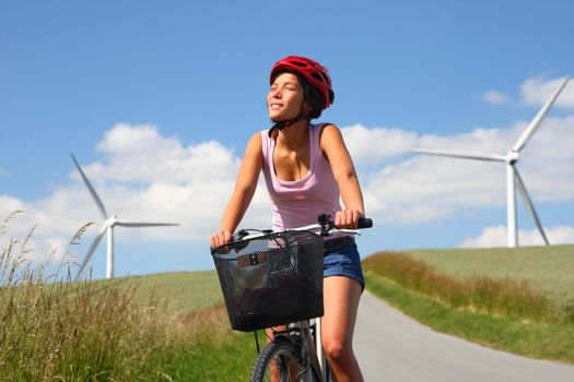 Woman relaxing and enjoying the sun on a bike trip in the countryside of Jutland, Denmark Windmill in the background.