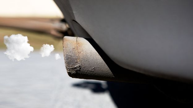 A car tail pipe with exhaust coming out, clean concept