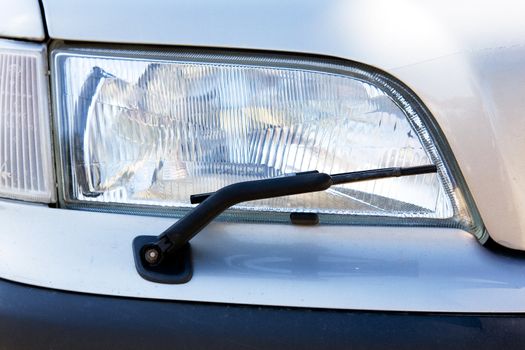 A headlight with a wiper detail on a car