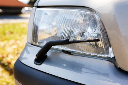 A headlight with a wiper detail on a car