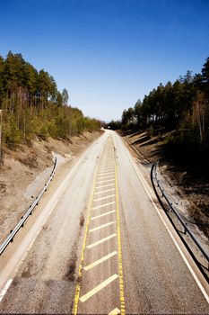 A highway stretching into the distance with a blue sky.