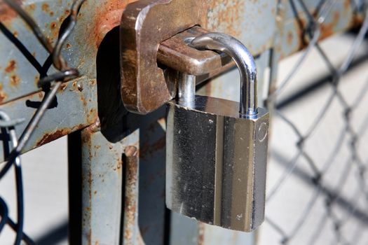 A heavy lock on a wire gate