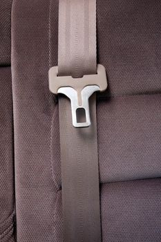 A seatbelt in a car with cloth seats