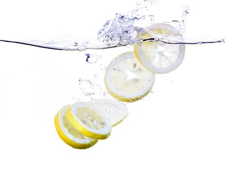 Lemon slices splashing in water - refreshing concept