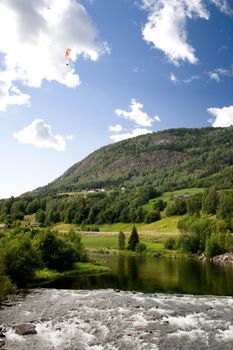 A Norwegian mountain landscape with a parachute in the sky