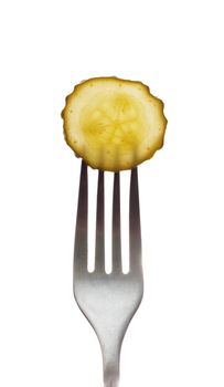 A fresh dill pickle on a fork isolated over white