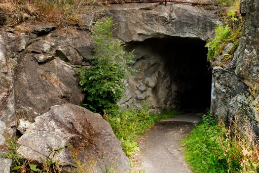 A path leading into a dark stone cave