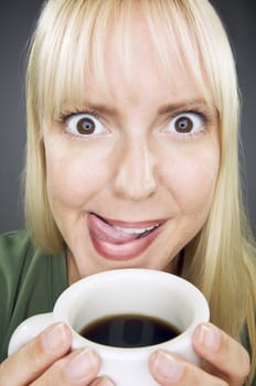 Beautiful Woman Enjoys Her Coffee Against a Grey Background.