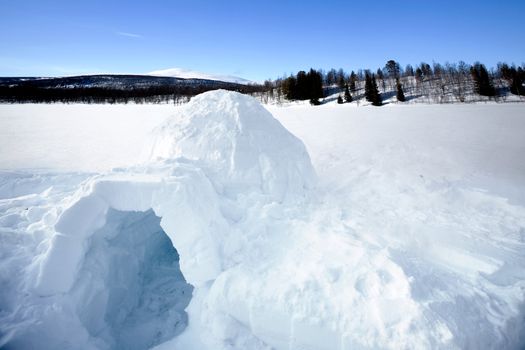 An igloo on a frozen lake in the mountains