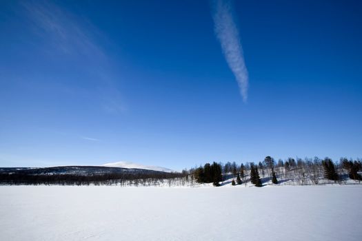 A mountain in the distance over a frozen lake.in winter.