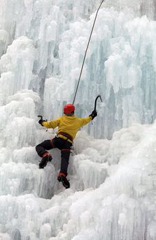 Ice climber on steep frozen waterfall