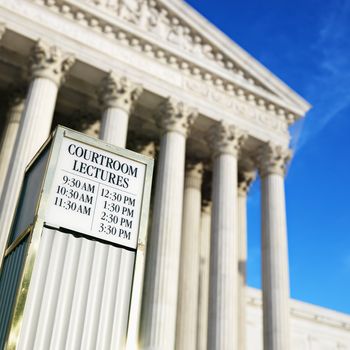 Courtroom lecture schedule sign in front of Supreme Court building in Washington DC.