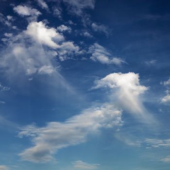 Wispy cloud formations against clear blue sky.